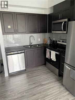 Waterloo condo for rent - A kitchen with dark brown cabinets and stainless steel appliances.