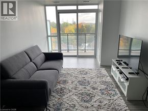 Waterloo condo for rent - A living room with a grey sofa and a patterned rug.