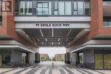 Vaughan condo for rent - The entrance to a building with the sign "99 Eagle Rock Way" and a bicycle parked in front.