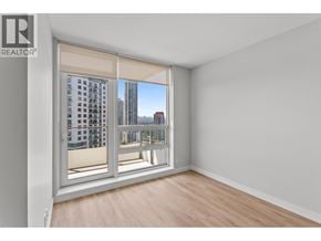 Coquitlam apartment for rent - A room with a sliding glass door leading to a balcony with a view of a cityscape.