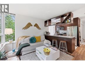 Vancouver apartment for rent - A living room with a white couch and a coffee table with a yellow vase on it.