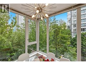 Vancouver apartment for rent - A dining room with a table set for two and a view of a forest outside the window.