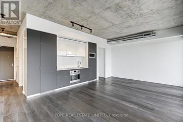 Toronto (Waterfront Communities) condo for rent - A modern kitchen with grey cabinets and a white countertop.
