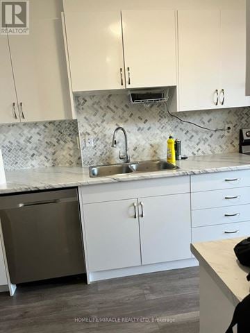 Hamilton (Vincent) condo for rent - A kitchen with white cabinets and a marble backsplash.