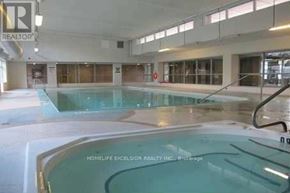 Toronto (Bendale) condo for rent - A large indoor swimming pool with a sign that says "HOMELIFE EXCELSIOR REALTY INC.".