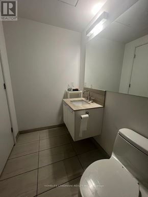 Toronto (Church-Yonge Corridor) condo for rent - A white bathroom with a toilet, sink, and mirror.