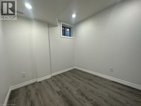 Brantford apartment for rent - A room with wooden flooring and white walls.
