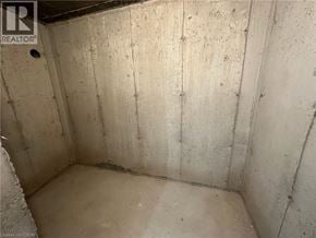 Brantford apartment for rent - A dirty, unfinished basement with concrete walls and floor.