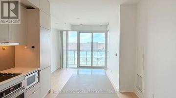 Toronto (Waterfront Communities) condo for rent - A modern kitchen with a stove top oven and microwave.