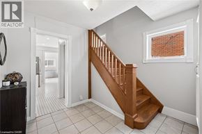 Kitchener apartment for rent - A wooden staircase leads up to a window in a white room.