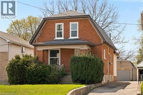 Kitchener apartment for rent - A brick house with a white window and a black roof.