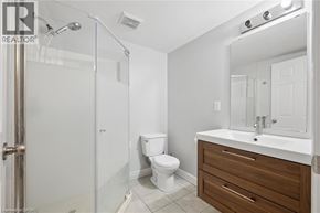 Kitchener apartment for rent - A white bathroom with a toilet, sink, and shower.