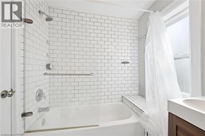 Kitchener apartment for rent - A white bathroom with a white tub and a white shower curtain.