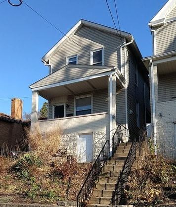 Pitcairn apartment for rent - A house with a staircase leading to the front door.