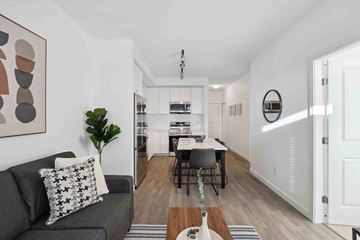 Surrey apartment for rent - A living room with a grey couch and a painting on the wall.