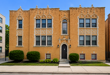 Chicago apartment for rent - A red brick building with a black door and windows.