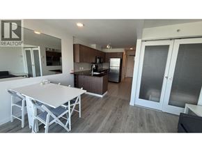 Vancouver apartment for rent - A white table and chairs are in a modern kitchen with a refrigerator and cabinets.