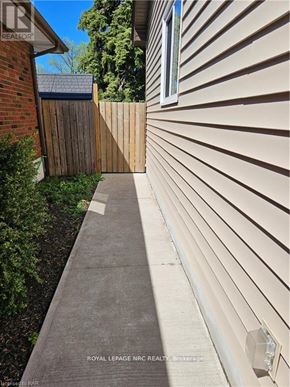 St. Catharines (Bunting/Linwell) apartment for rent - A house with a grey siding and a wooden fence.