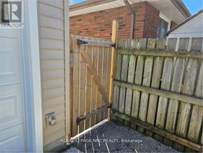 St. Catharines (Bunting/Linwell) apartment for rent - A wooden gate is closed in front of a brick wall.
