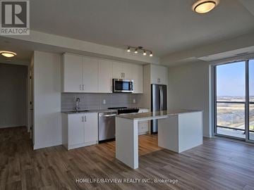 Oakville (Jm Joshua Meadows) condo for rent - A kitchen with white cabinets and a wooden floor.