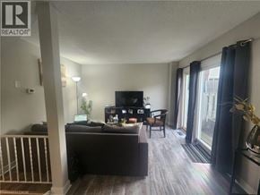 Cambridge townhouse for rent - A living room with a couch, television, and a window with curtains.