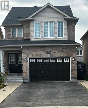 Brampton (Fletcher's Creek South) apartment for rent - A two-story house with a black garage door is for sale.