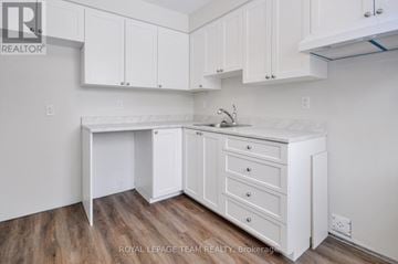 Ottawa townhouse for rent - A white kitchen with a sink and cabinets.