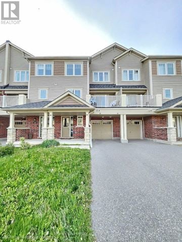 Oshawa (Windfields) townhouse for rent - A large, multi-story residential building with a balcony and multiple garage doors.