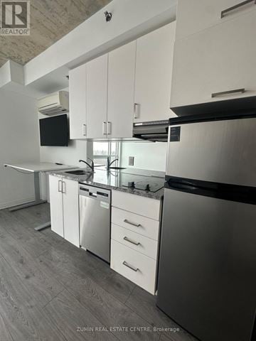 Oshawa (Samac) condo for rent - A modern kitchen with white cabinets and stainless steel appliances.