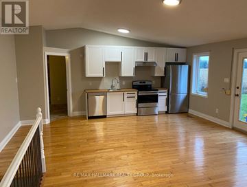 Ottawa apartment for rent - A kitchen with white cabinets and a wooden floor.