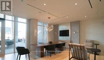 Toronto (Regent Park) house for rent - A modern living room with a black chair and a wooden table.