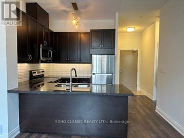 Vaughan (Maple) condo for rent - A kitchen with black cabinets and a black countertop.