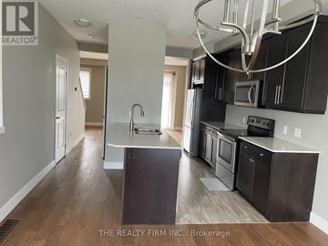 London North (North E) townhouse for rent - A kitchen with dark wood cabinets and a black stove top oven.