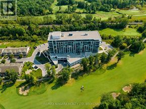 Niagara Falls (Oldfield) condo for rent - An aerial view of a large building surrounded by a grassy area with trees.