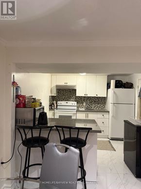 Toronto (Malvern) apartment for rent - A kitchen with white cabinets and a black counter top.