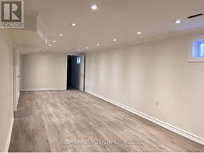 Toronto (Malvern) apartment for rent - A spacious room with a door at the end and a window on the right wall.
