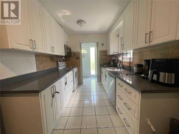 Toronto (Malvern) apartment for rent - A kitchen with white cabinets and a tile floor.