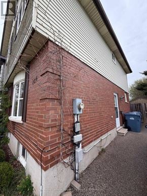 Guelph (Kortright West) apartment for rent - A red brick house with a white window and a metal pipe on the side.