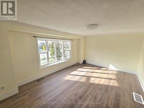 Guelph (Kortright West) apartment for rent - A room with wooden flooring and a window letting in sunlight.
