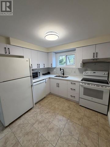 Guelph (Kortright West) apartment for rent - A kitchen with white appliances and cabinets.