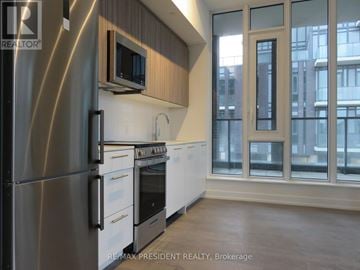 Brampton (Northwest Brampton) condo for rent - A modern kitchen with stainless steel appliances and wooden cabinets.