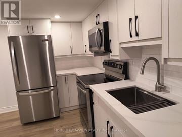 Markham (Grandview) apartment for rent - A modern kitchen with a stainless steel refrigerator and black countertops.