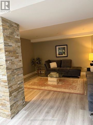 Vaughan (East Woodbridge) apartment for rent - A stone pillar stands next to a couch in a living room.