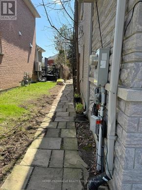 Vaughan (East Woodbridge) apartment for rent - A stone pathway leads to a house with a realtor sign.