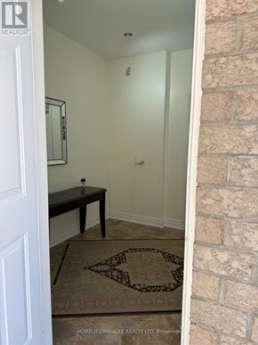Vaughan (East Woodbridge) apartment for rent - A hallway with a brick wall and a rug on the floor.