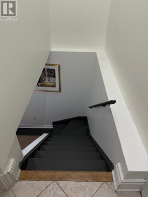 Vaughan (East Woodbridge) apartment for rent - A staircase with a black carpet and wooden steps.