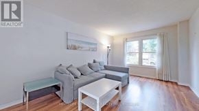 Mississauga (Erin Mills) apartment for rent - A living room with a grey couch and a white coffee table.