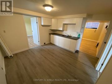 Cornwall apartment for rent - A kitchen area with white cabinets and a wooden floor.