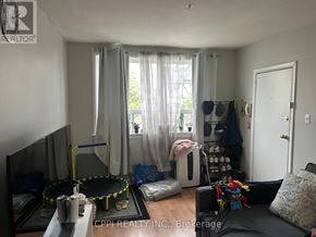Ajax (Central West) multi-family for rent - A living room with a black couch, a coffee table, and a TV.