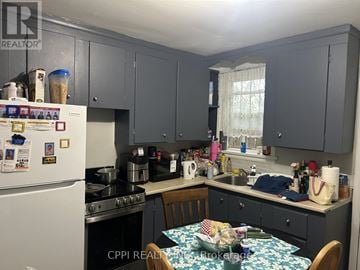 Ajax (Central West) multi-family for rent - A kitchen with a table and chairs in front of it.